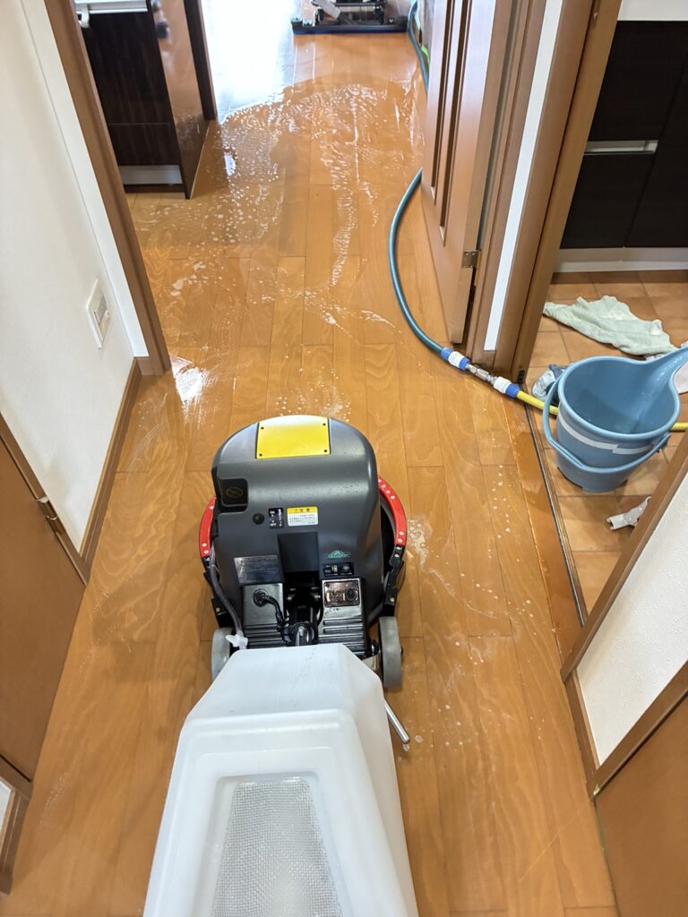 木目調の床を洗浄機で剥離作業中の廊下